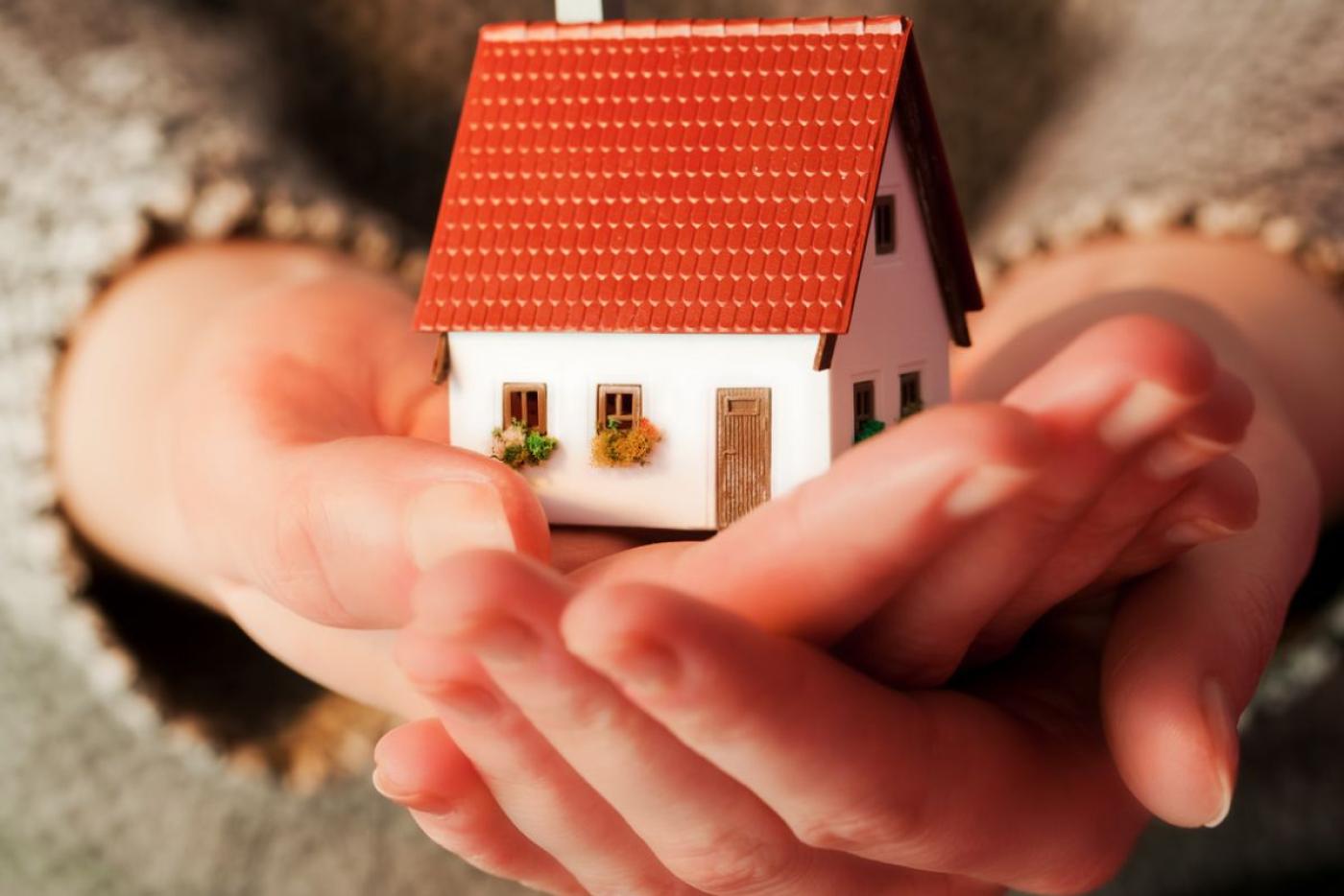 hands cupped holding a small home