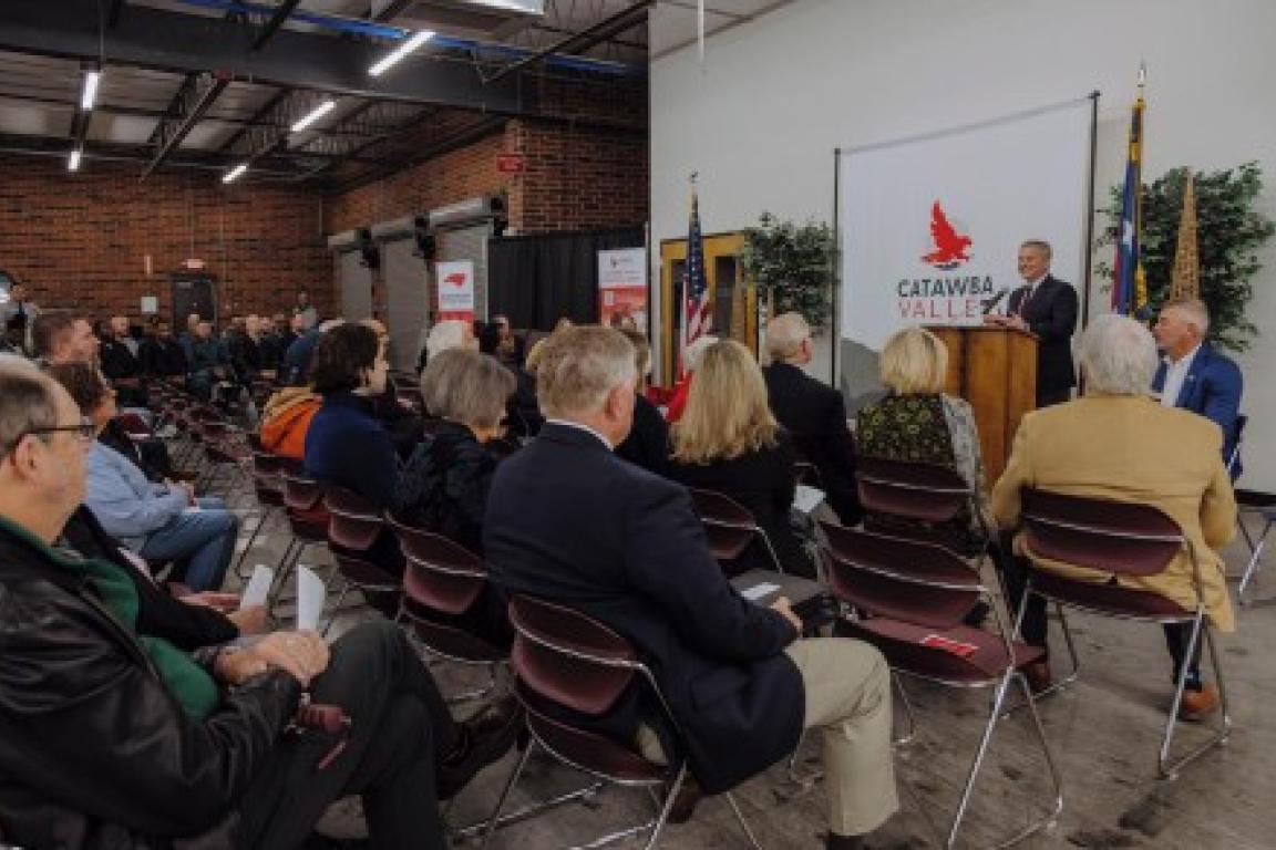 governor stein at podium speaking to men and women in large room