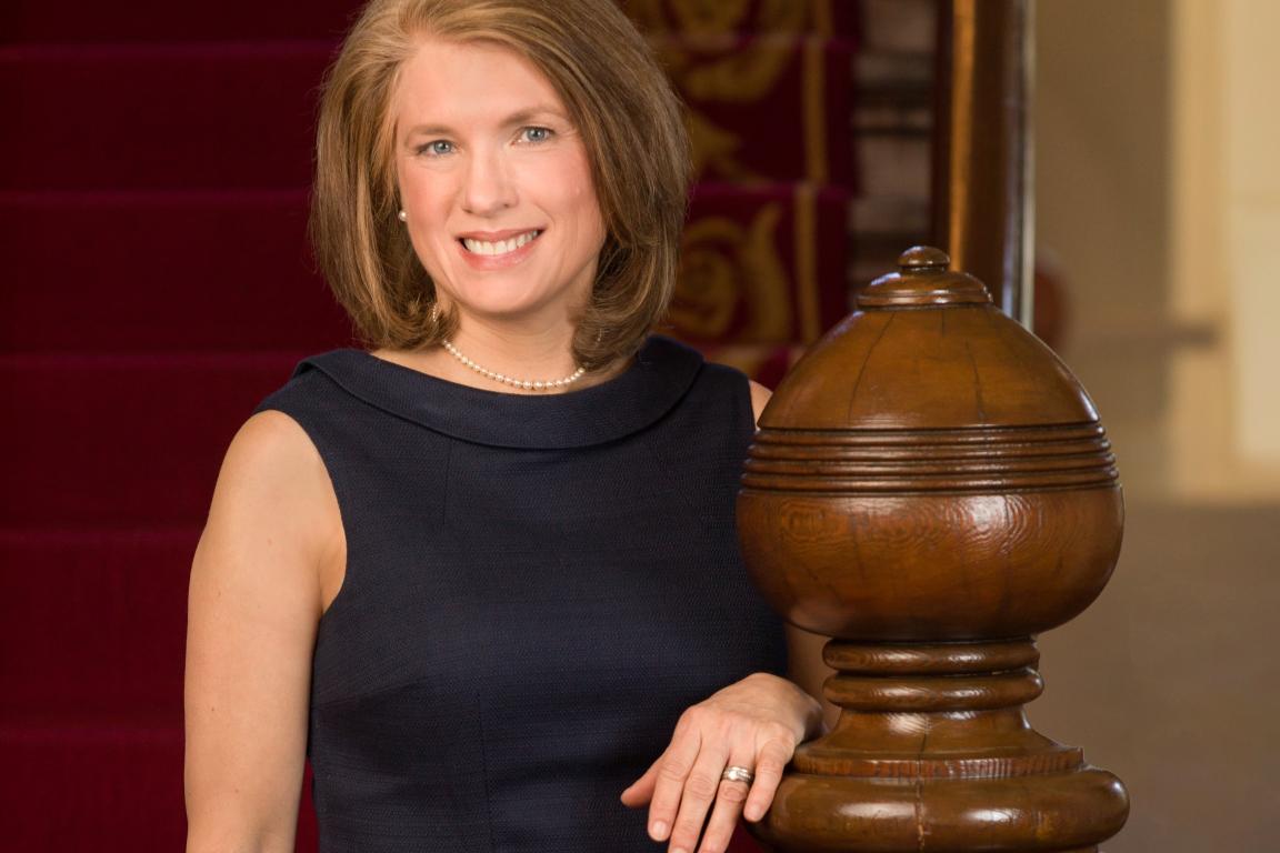 N.C. First Lady Anna Stein, dark dress standing next to stair railing