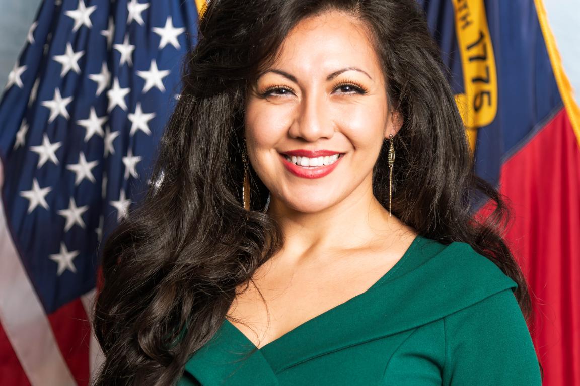 woman with long black hair and green dress