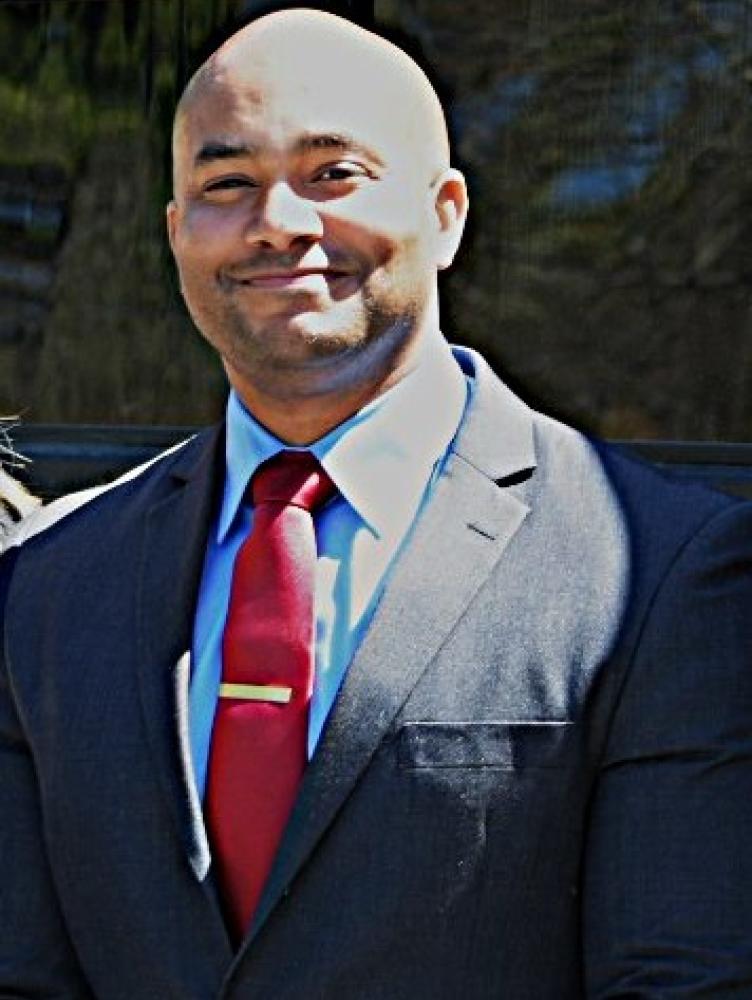 Kerwin Pittman bald man with charcoal gray suit, red tie, blue shirt