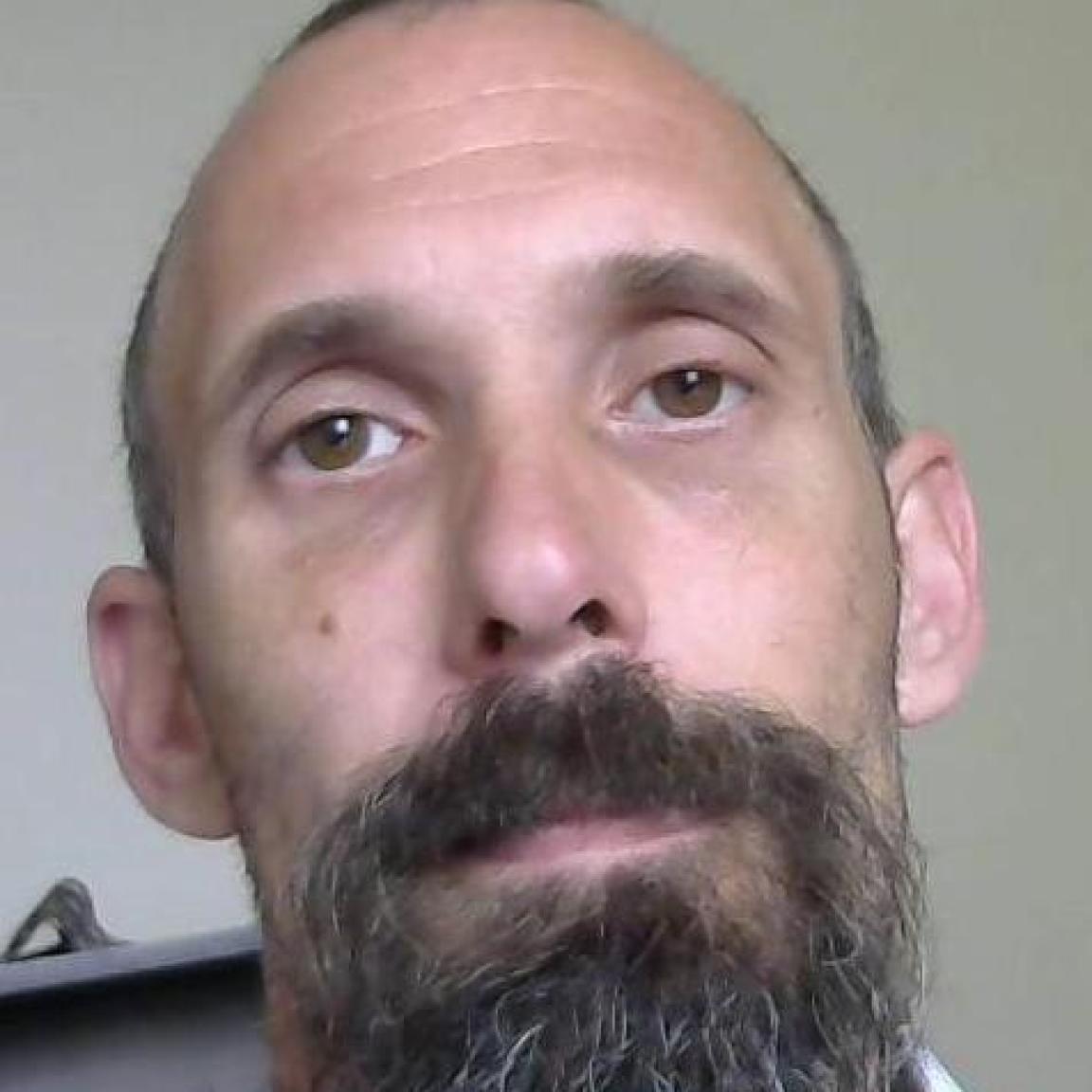 White man bald mostly with medium beard brown hair that is greying in it mugshot