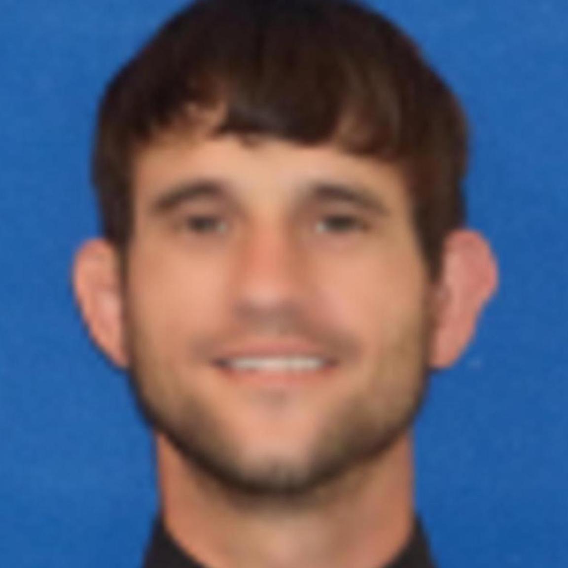 middle aged man with brown hair and close cut beard. white.