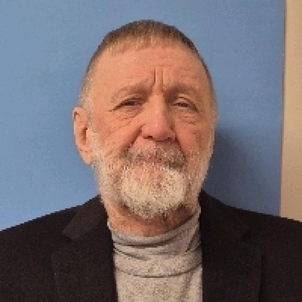 senior man with short cropped brown hair and full white bearch