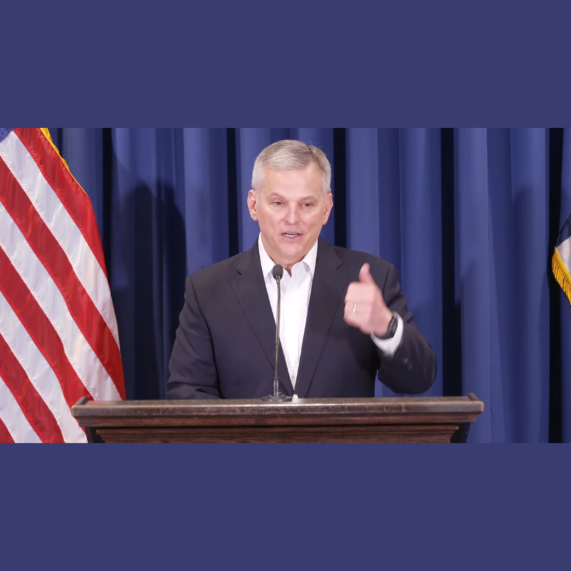 Gov. Stein at podium with thumbs up