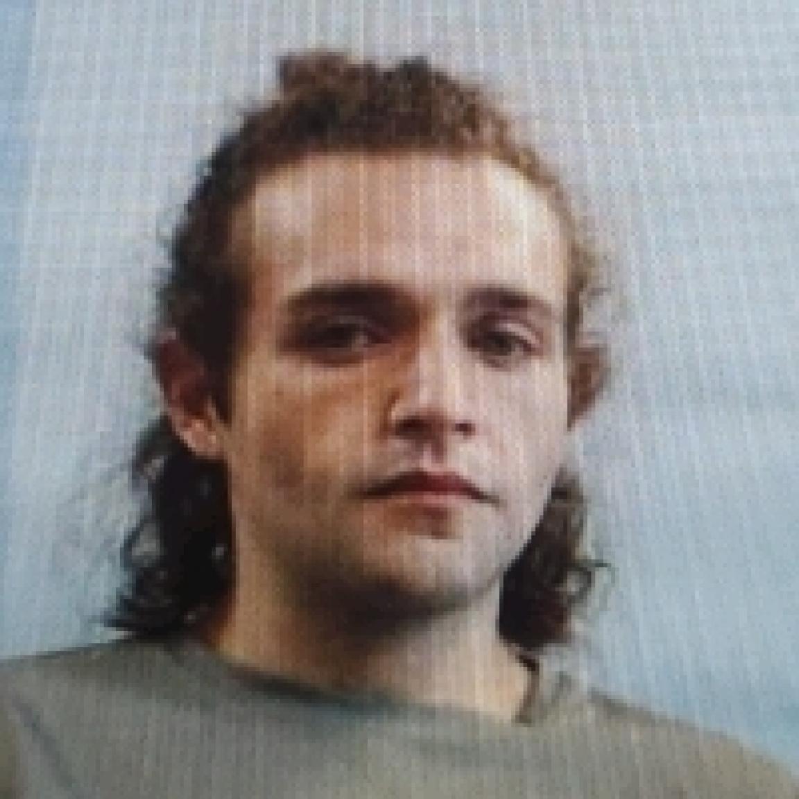 white man young with curly brown hair in pony tail