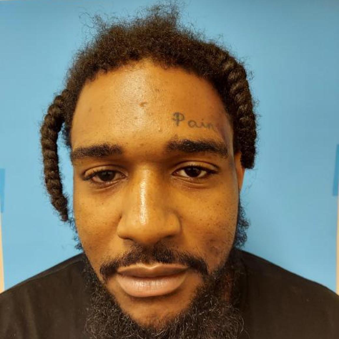 black man mustache short hair with tattoo on forehead