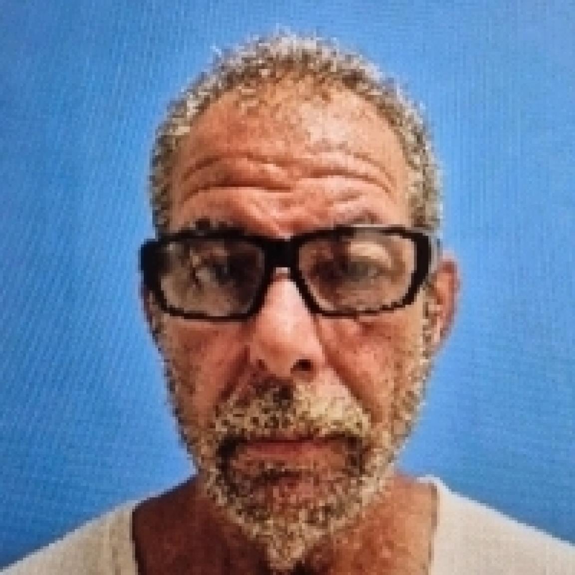 white man with black glasses and short grey hair and beard