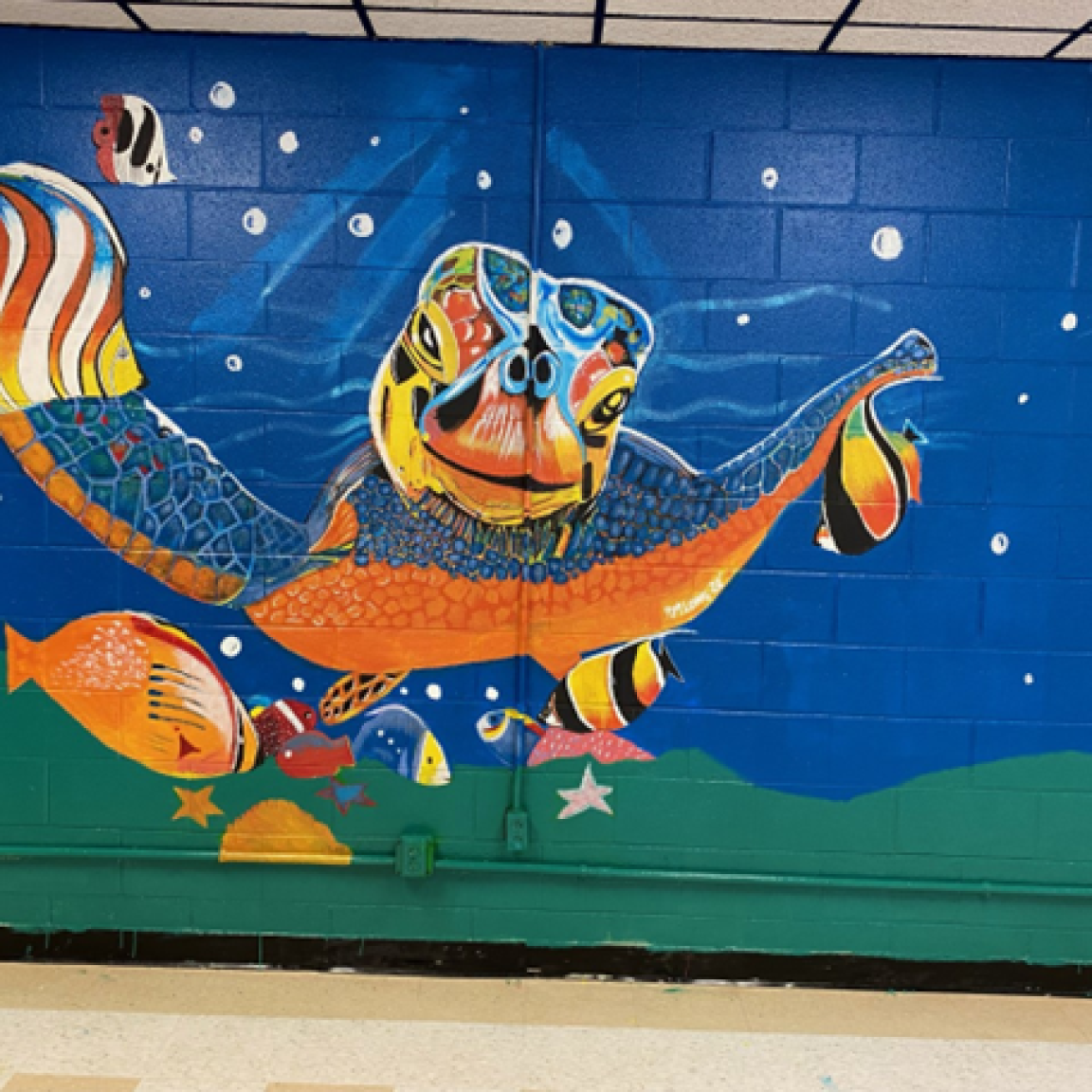 mural of turtle and fish and undersea life painted on a wall inside 