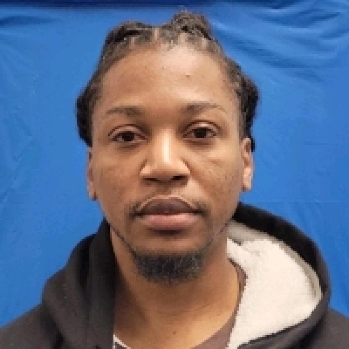 young black man with dredlocks pulled in ponytail in hoodie