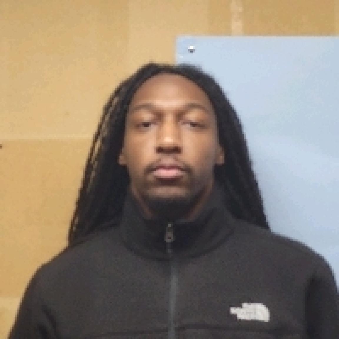 young black man with dredlocks and fu man choo in black hoodie