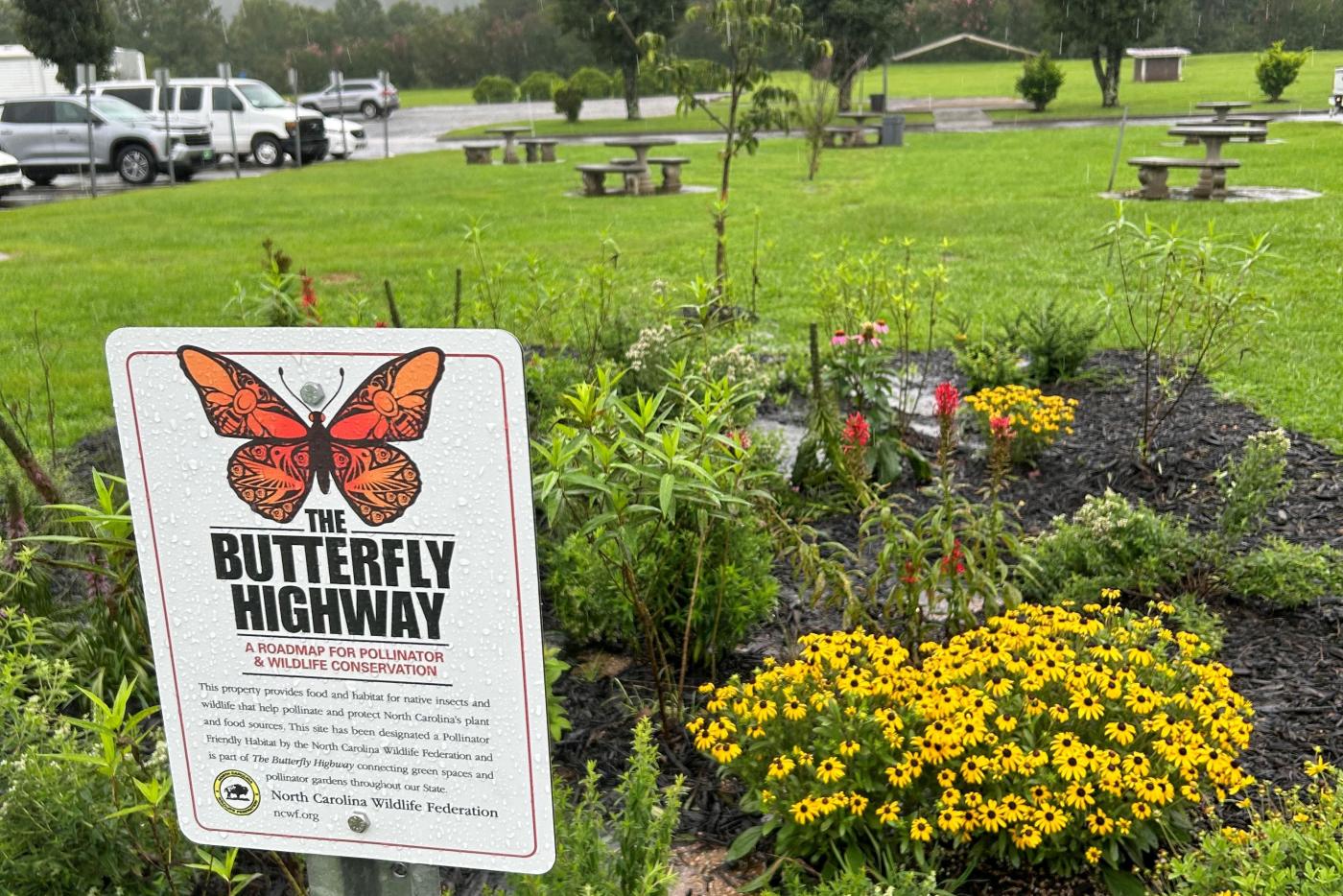 pollinator garden sign in front of newly planted garden