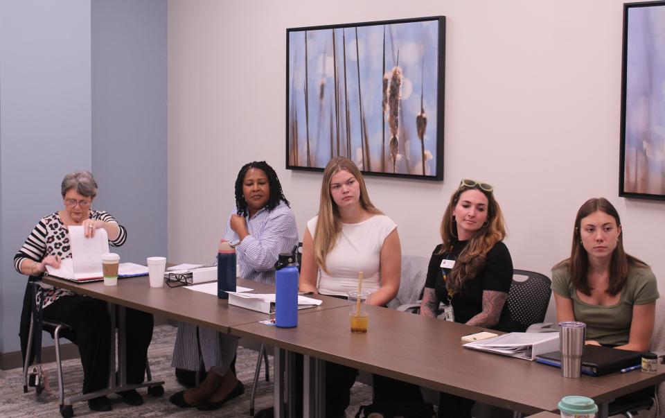 CPE female interns, with NCDAC personnel, sit at a table during a discussion.