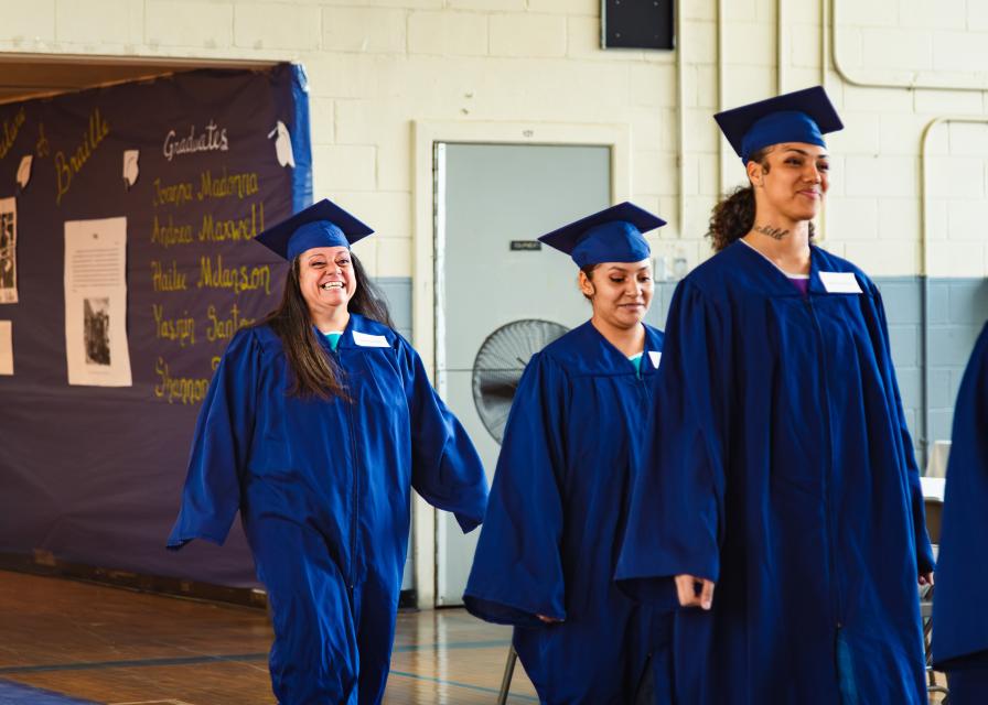 Graduate women in gown smiling