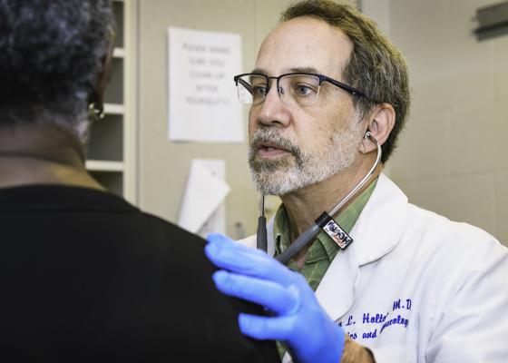 a white older gentleman is a doctor and he is speaking to a patient