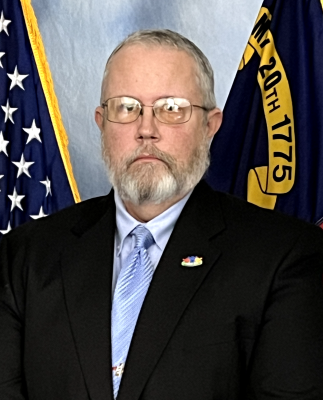 Robert Norvel in front of US and NC flags