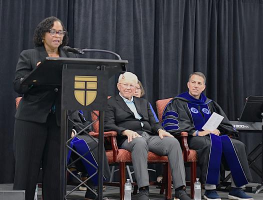 NCDAC Chief Operating Officer Tammera Hill speaks at convocation with Joe Gibbs and SEBTS President Scott Pace on stage