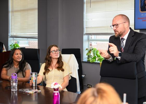 two interns listen to session leader at table
