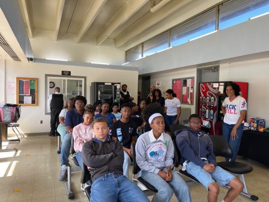 A group of teens and adult chaperones from Jack and Jill of America gather in the lobby of Central Prison during an educational tour.