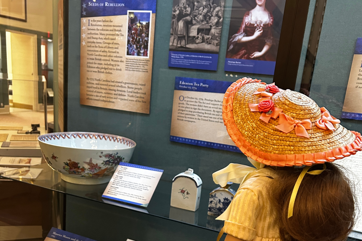 Felicity doll viewing a museum display about colonial tea customs.