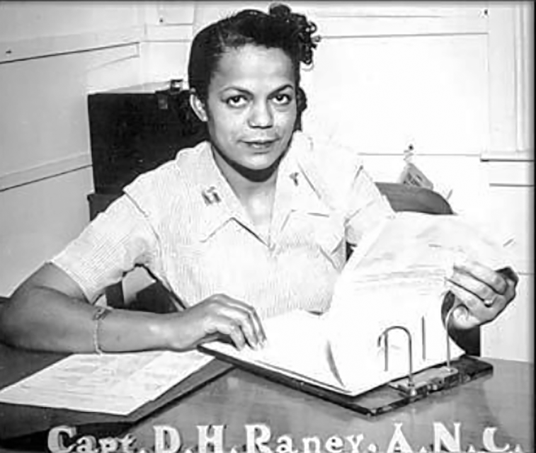Della Raney sitting at a desk with paperwork
