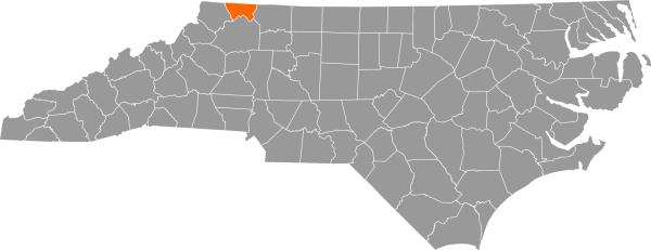 A gray map of North Carolina with Alleghany County filled in with orange.