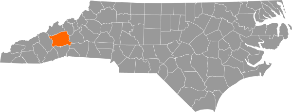 A gray map of North Carolina with Buncombe County filled in with orange.