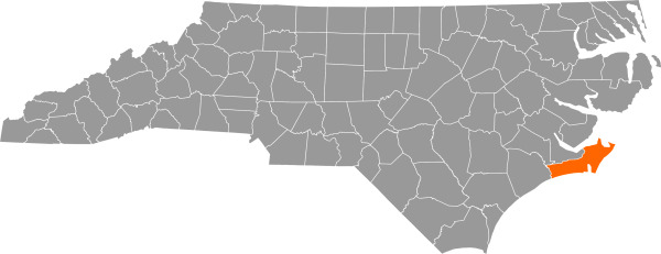 A gray map of North Carolina with Carteret County filled in with orange.