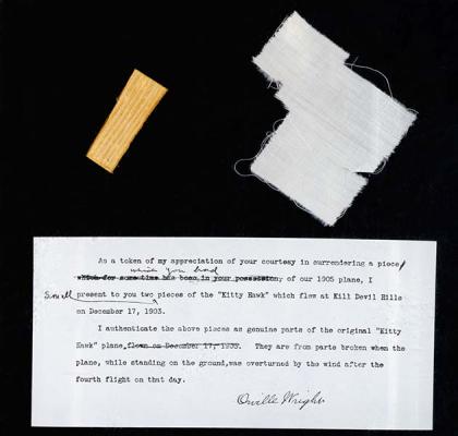 Fragments of the original Wright Flyer alongside a brief typed note in which Orville Wright authenticates the pieces.