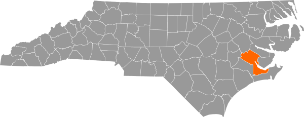 A gray map of North Carolina with Craven County filled in with orange.