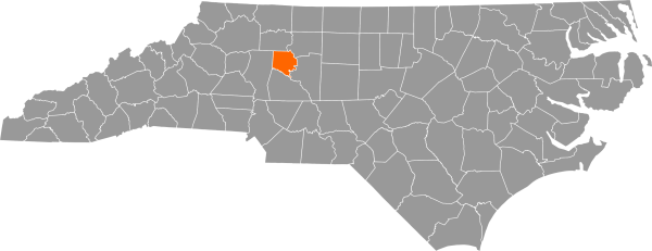 A gray map of North Carolina with Davie County filled in with orange.