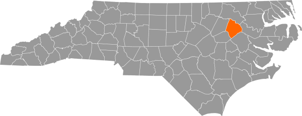 A gray map of North Carolina with Edgecome County filled in with orange.