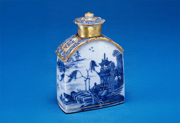Blue and white porcelain bottle with a gold-accented lid, decorated with a landscape scene featuring trees, water, and a building.