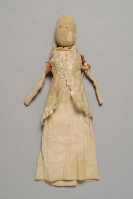 Cloth doll with a simple drawn face and long dress, showing signs of wear and age.