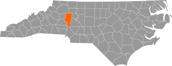 A gray map of North Carolina with Iredell County filled in with orange.