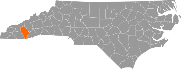 A gray map of North Carolina with Jackson County filled in with orange.