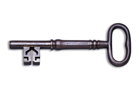 An antique metal key lying horizontally.