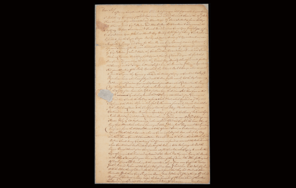 An aged, handwritten letter on yellowed paper with frayed edges and a small tear, featuring dense cursive script that fills the page.