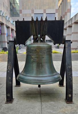 Liberty Bell replica displayed outdoors on a black steel frame.