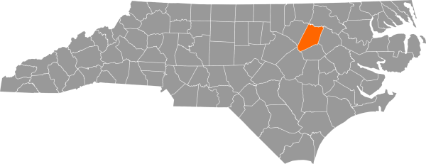 A gray map of North Carolina with Nash County filled in with orange.