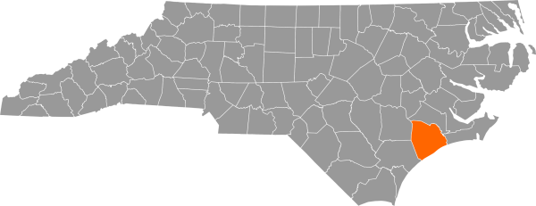 A gray map of North Carolina with Onslow County filled in with orange.