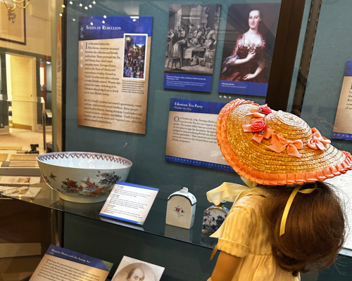 Felicity doll viewing a museum display about colonial tea customs.