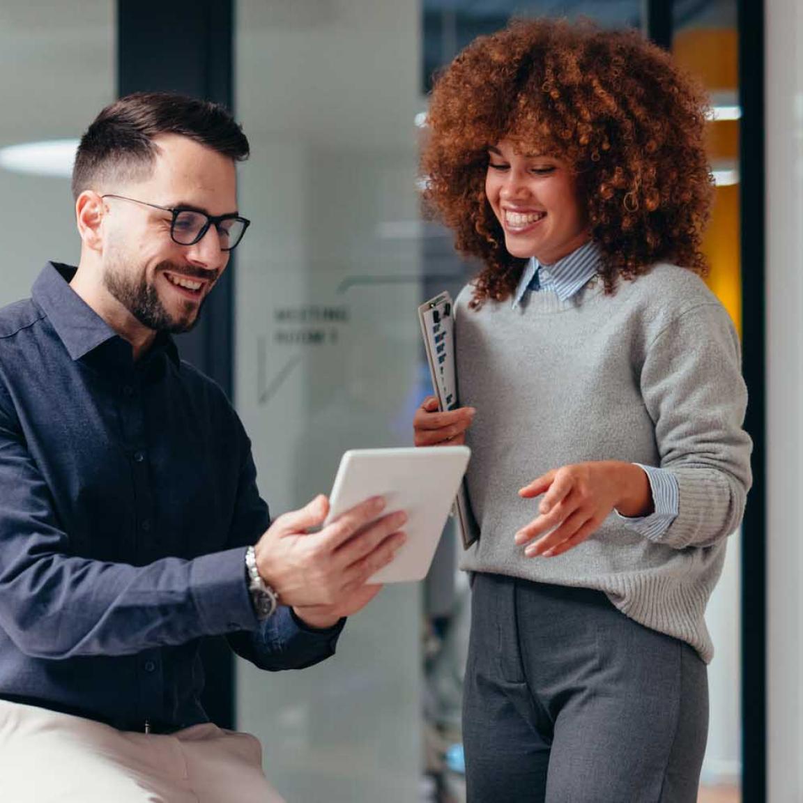 A man and woman work together in a modern office setting.