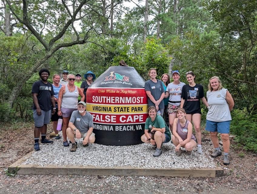 Group posed at false cape entrance sign