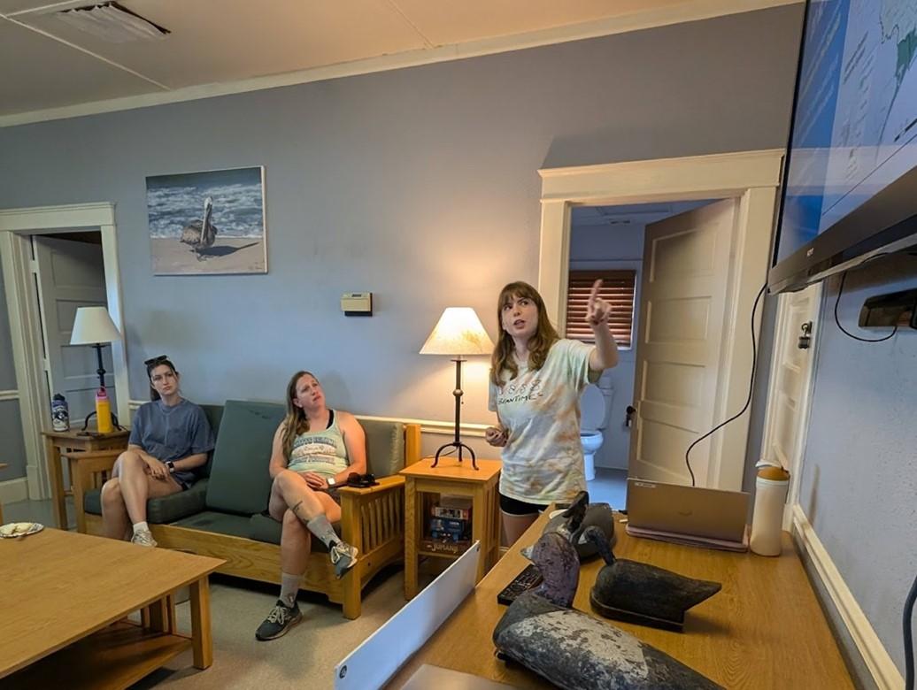 Katie giving a presentation in a coastal decorated room