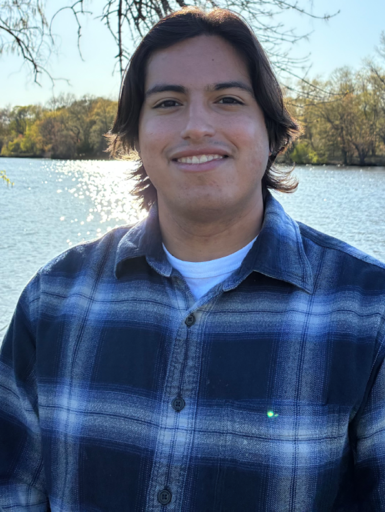 Giancarlo Richardson smiling in front of a body of water