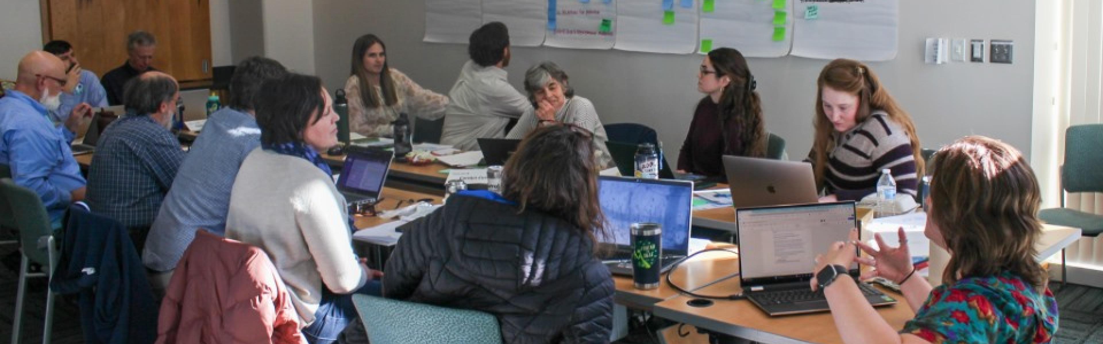 Group around long table with writing in the background