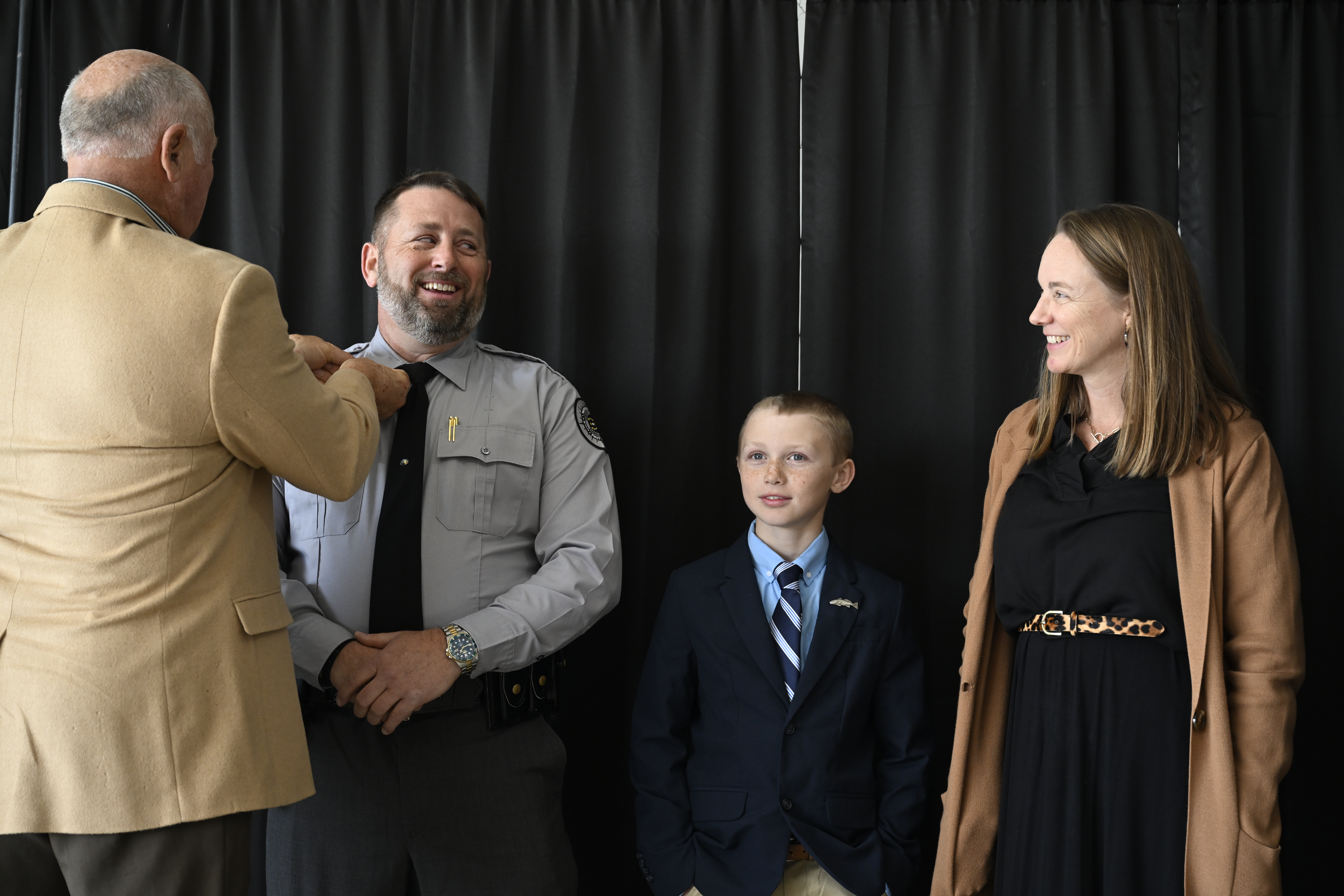 Colonel Chris Lee getting pinned by his father beside his son and wife.