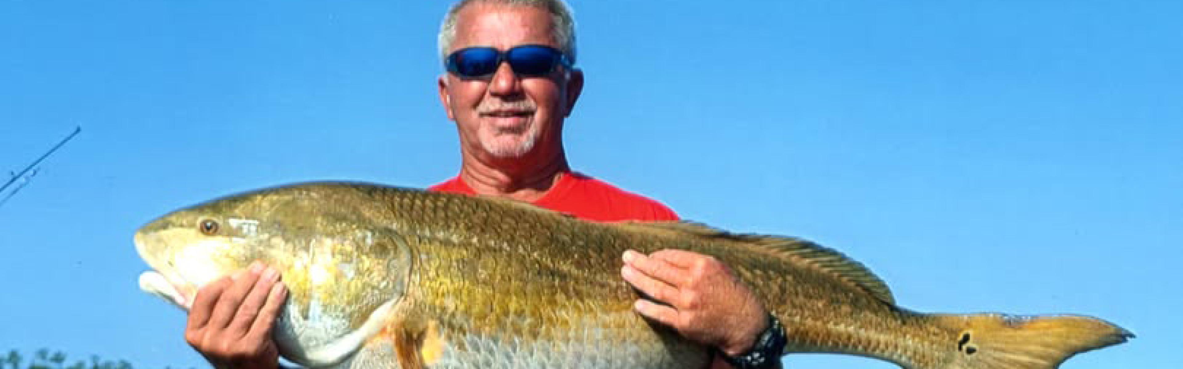 Man holding up big red drum