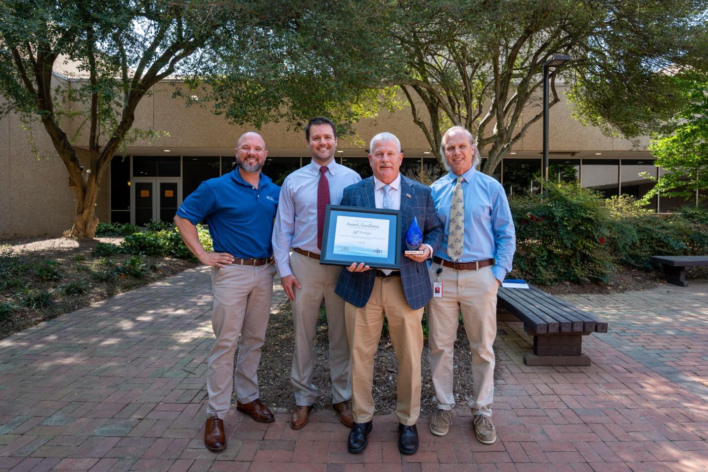 Award-winner Jeff Lineberger (second from right) holds a Source Water Protection Award certificate along with, from left, Brett Hartis of Duke Energy, Brad Whitman of NCDEQ and Danny Edwards of NCDEQ. Photo by Dan DiNicola, NC State University. 